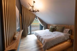 a bedroom with a bed with a large window at Sadova Chalet in Sadova