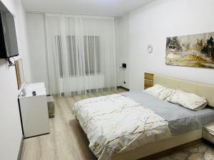 a bedroom with a bed and a flat screen tv at Casa Bradu in Mangalia