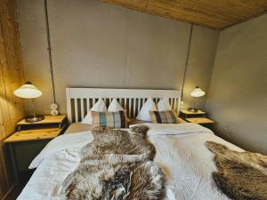 a bedroom with a bed with a blanket and two lamps at The Forgotten Farmhouse in Skogar