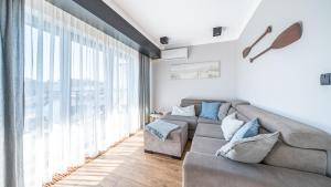 a living room with a couch and a large window at Bulwar Portowy, Sun & Snow in Ustka