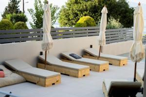 a patio with two chairs and two umbrellas at Theros Suites in Dhiminión