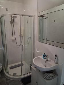 a bathroom with a glass shower and a sink at DRIFTWOOD coastal holiday flat - newly refurbished with 2 bedrooms in Largs +10 photos