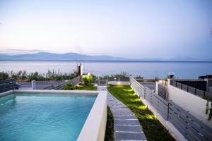a swimming pool with a view of the water at Theros Suites in Dhiminión