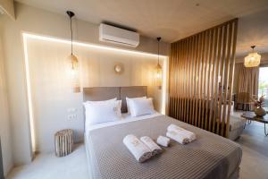a bedroom with a bed with two towels on it at Theros Suites in Dhiminión +29 photos