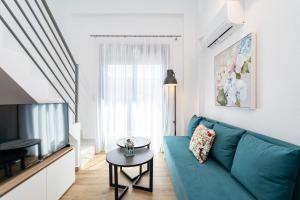 a living room with a blue couch and a tv at Erato Residential Complex in Ofrínion