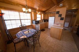 a kitchen with a table and chairs and a refrigerator at Long Lake Resort in Poteau