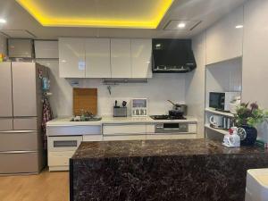 a kitchen with white cabinets and a black counter top at コテージ銚子百里 in Hasaki