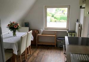 a kitchen with a table with a vase of flowers on it at Handwerkerunterkunft in Elmshorn
