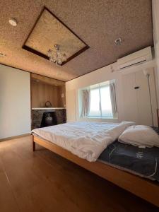 a bedroom with a large bed with a ceiling at コテージ銚子百里 in Hasaki