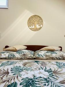 a bed with two pillows and a plate on the wall at Apartman Zamak Sombor in Sombor