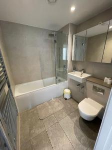 a bathroom with a toilet and a tub and a sink at LUXURY SERVICED APARTMENT***** in Croydon