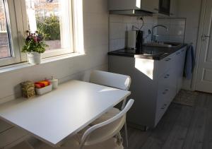 a kitchen with a white table and a sink at Tiny House Near Skokloster Castle in Uppsala