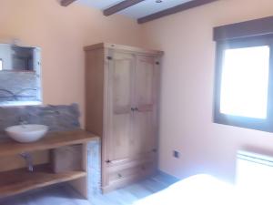 a bathroom with a sink and a wooden cabinet at La Veiga Apartamentos Turísticos in La Riera +22 photos
