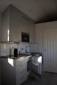 a kitchen with white cabinets and a sink at Tiny House Near Skokloster Castle in Uppsala +21 photos