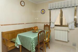 a dining room with a table and chairs and a clock at La Veiga Apartamentos Turísticos in La Riera