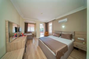 a bedroom with a large bed and a television at Sava Hotel in Antalya
