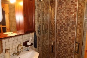 a bathroom with a sink and a shower at Casa Plaiul Cailor: Rustic Mountain Hideaway in Proviţa de Sus