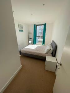a small bedroom with a bed and a window at LUXURY SERVICED APARTMENT***** in Croydon