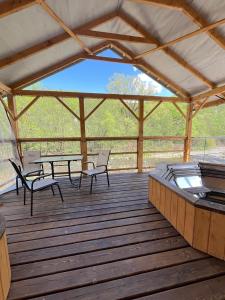 a pavilion with chairs and tables on a wooden deck at Vivat in Solochyn