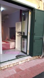 ジャルディーニ・ナクソスにあるCasa Mareのベッド付きの部屋への開放ドア