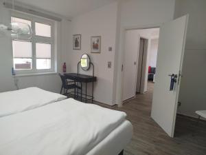 a bedroom with a bed and a desk and a window at Ferienwohnung Friederike Luise in Bad Freienwalde