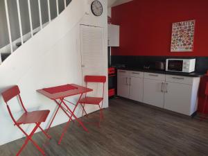a red kitchen with a table and two chairs and a counter at Ferienwohnung Friederike Luise in Bad Freienwalde
