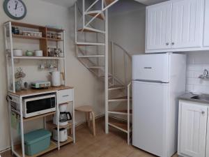 a kitchen with a white refrigerator and a shelf at Little Kristi in Palaiókastron