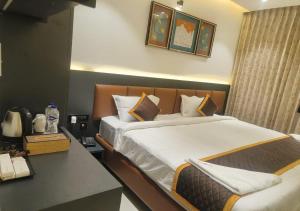 a hotel room with a bed and a desk at K R GRAND in Vijayawāda