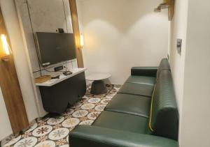 a living room with a couch and a tv at K R GRAND in Vijayawāda
