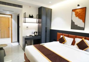 a bedroom with a large bed and a desk at K R GRAND in Vijayawāda +19 photos