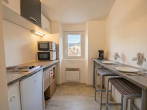 a kitchen with a counter with a microwave and a window at Studio La Vague - Idéal Couple en Escapade Provence Hors Foules - Marché Samedi à Pied - Bois de la Lare 6km - CENTRE VILLE Auriol - Marseille 27km - Aubagne 11km - WIFI HD - Climatisation in Auriol +12 photos