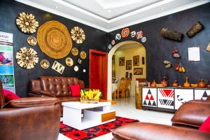 a living room with leather furniture and a black wall at Virunga House in Ruhengeri