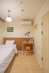 a bedroom with a bed and a desk with a fan at Wayhome Gasan in Seoul