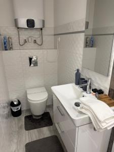 a white bathroom with a toilet and a sink at ILK Residence in Balatonalmádi +16 photos