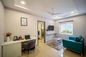 a living room with a desk and a blue couch at New Prestige Hotel in Hyderabad +11 photos
