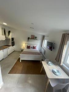 a white room with a bed and a table at Chene Résidence Viry chatillon in Viry-Châtillon