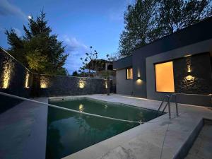 a swimming pool in front of a house at night at Casa Matthias in Kavadarci
