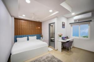 a bedroom with a bed and a desk and a window at New Prestige Hotel in Hyderabad