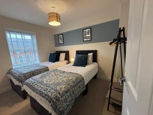 two beds in a room with a camera on a tripod at 3 Beds with off-street parking for 2 cars, fast Wifi, sleeps 6 in Ashby de la Zouch