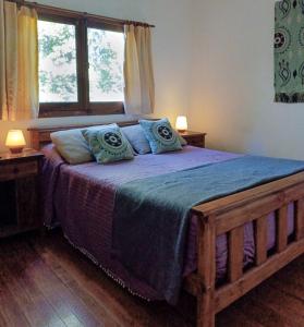 a bedroom with a large wooden bed with blue pillows at Quinta Las Marías - Domingos Check out 17 hs in Tigre