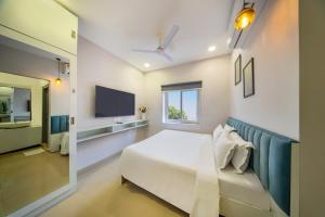 a bedroom with a white bed and a television at New Prestige Hotel in Hyderabad