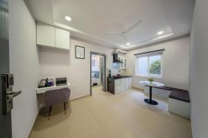 a kitchen and living room with a desk and a table at New Prestige Hotel in Hyderabad