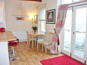a living room with a table and chairs and a window at Watch House in Fowey