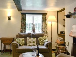 a living room with a couch and a window at Yew Tree Cottage in Arford