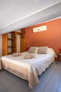 a bedroom with a large white bed with an orange wall at Le Bouquet de l Aromate in Joucas +34 photos
