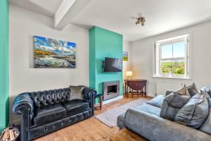 a living room with a couch and a tv at John Brown Cottage in Skipton