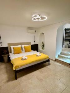 Un dormitorio con una cama con sábanas amarillas y almohadas amarillas. en Arena Prestige Rooms, en Pula
