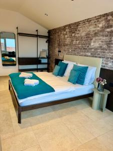 un dormitorio con una cama grande con almohadas azules en Arena Prestige Rooms, en Pula 29 fotos más