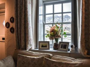 a window with a vase of flowers and framed pictures at Summerhill Tanyrhos in Blaenau-Ffestiniog