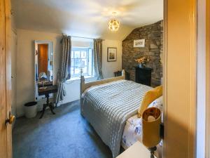 a bedroom with a bed and a stone wall at Summerhill Tanyrhos in Blaenau-Ffestiniog +11 photos